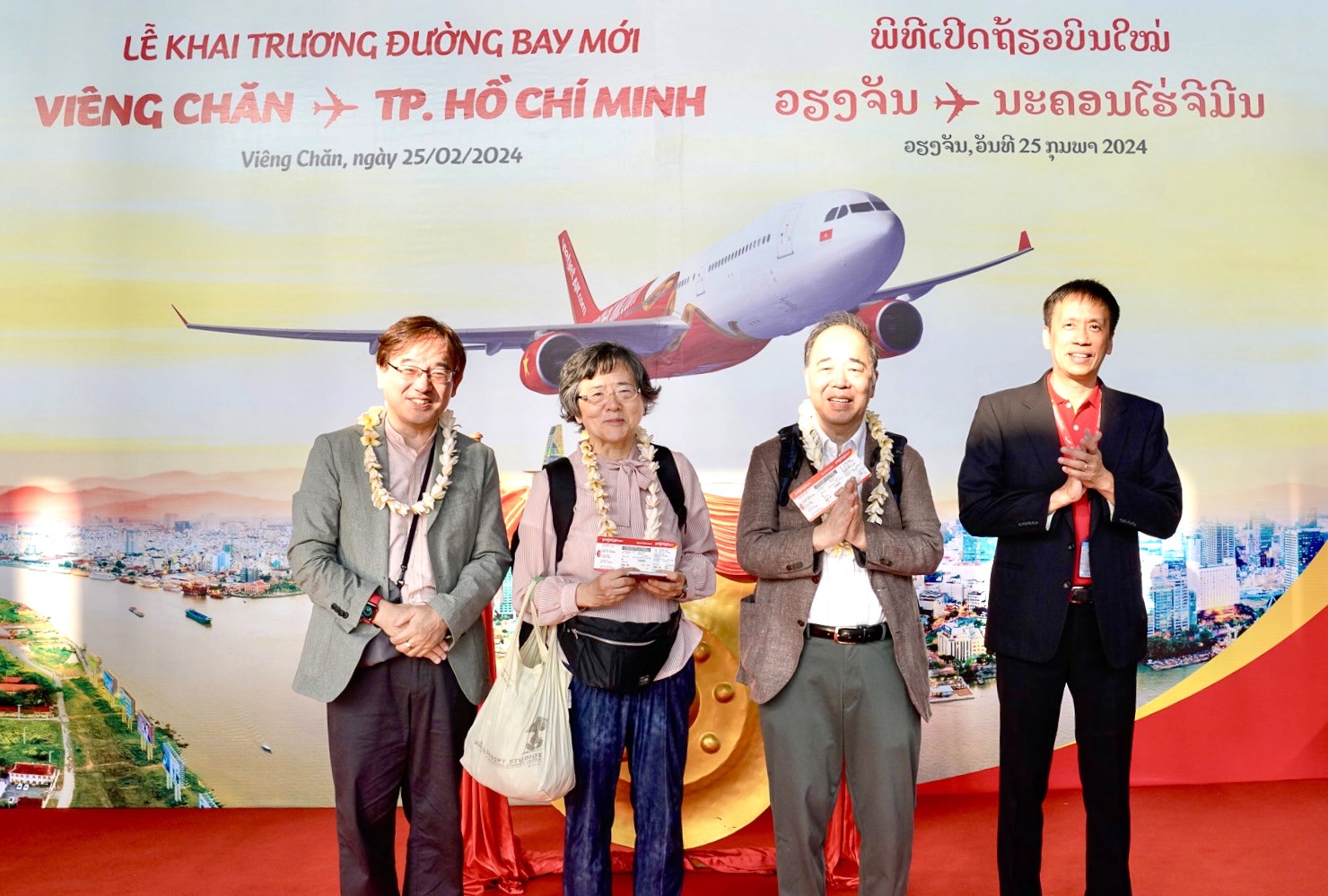 Phó Tổng giám đốc Vietjet Nguyễn Thanh Sơn tặng hoa và quà lưu niệm cho những hành khách đầu tiên 