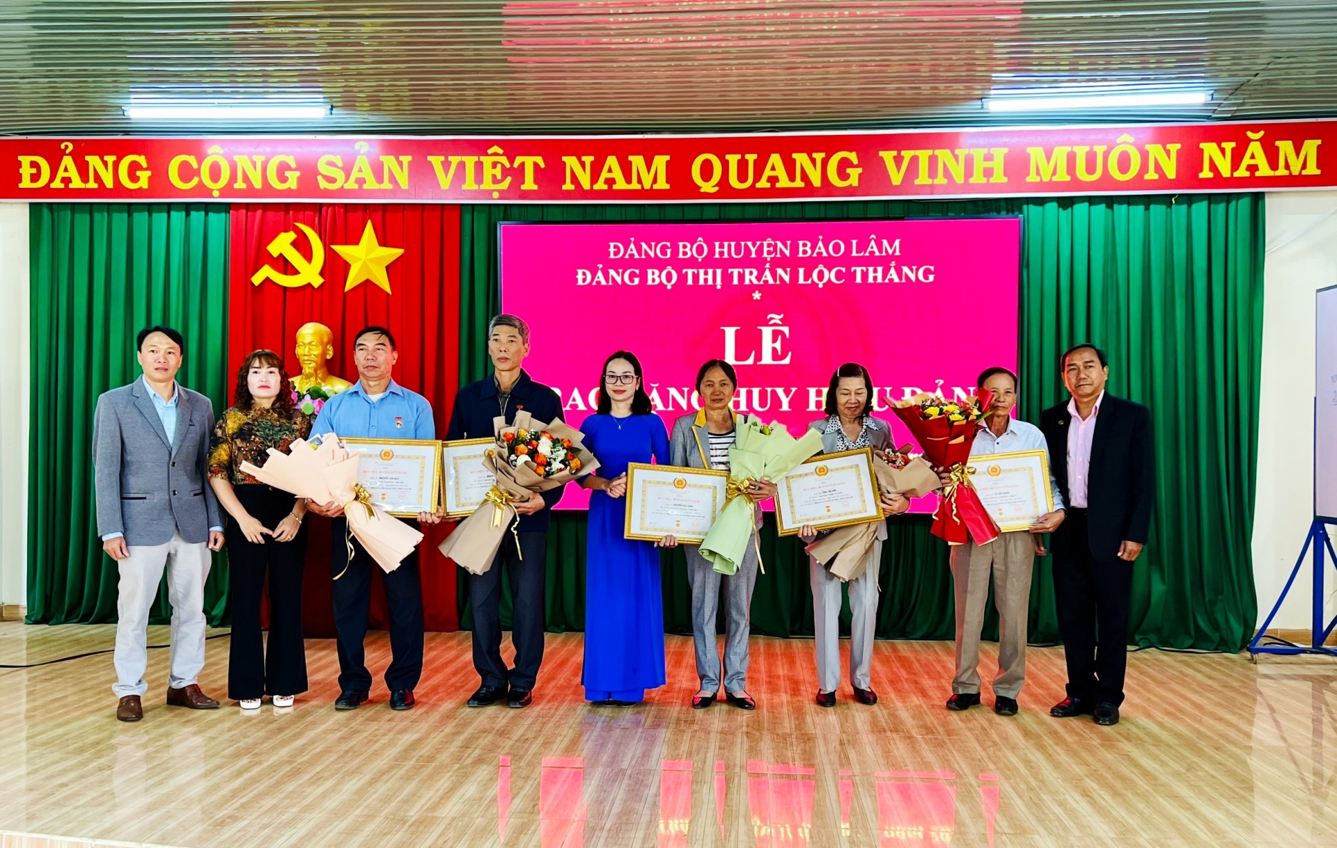 Đồng chí KLình - Phó Bí thư Thường trực Huyện ủy Bảo Lâm, Chủ tịch HĐND huyện trao tặng Huy hiệu Đảng cho các đảng viên tại thị trấn Lộc Thắng