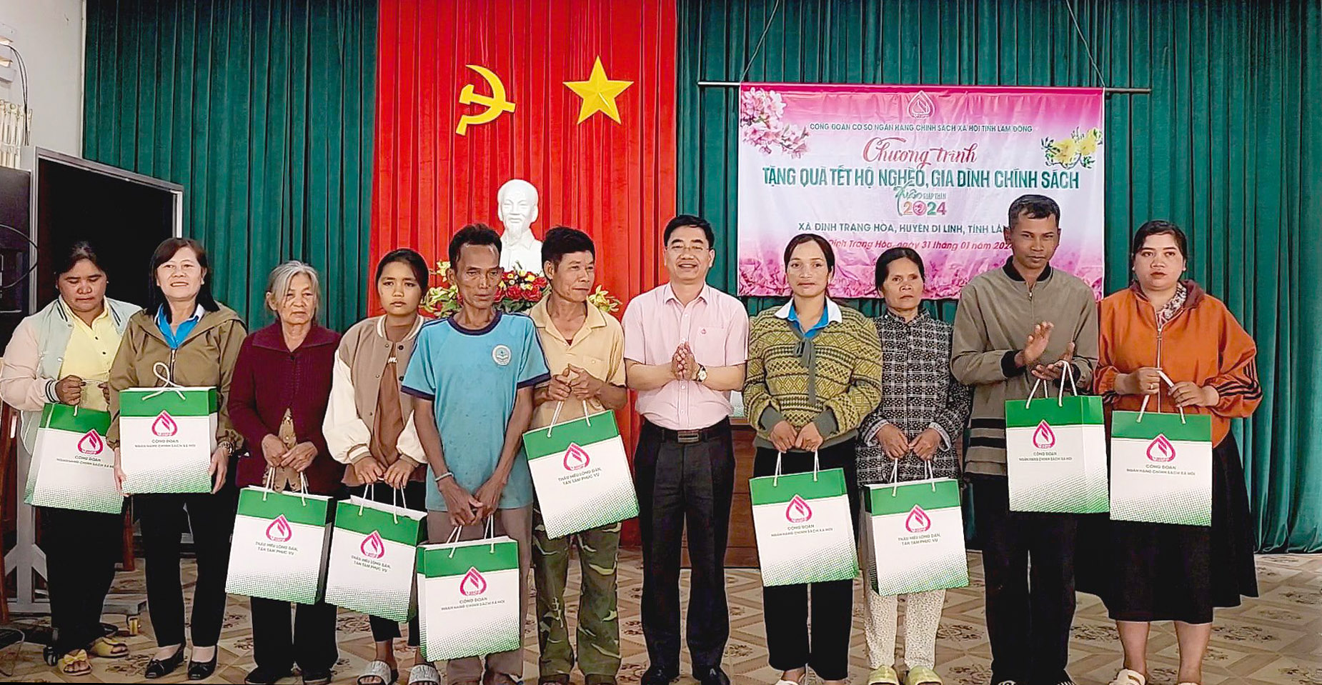 Ông Nguyễn Trung Kiên (áo hồng - giữa) - Phó Giám đốc NHCSXH trao quà Tết cho các hộ gia đình ở huyện Di Linh
