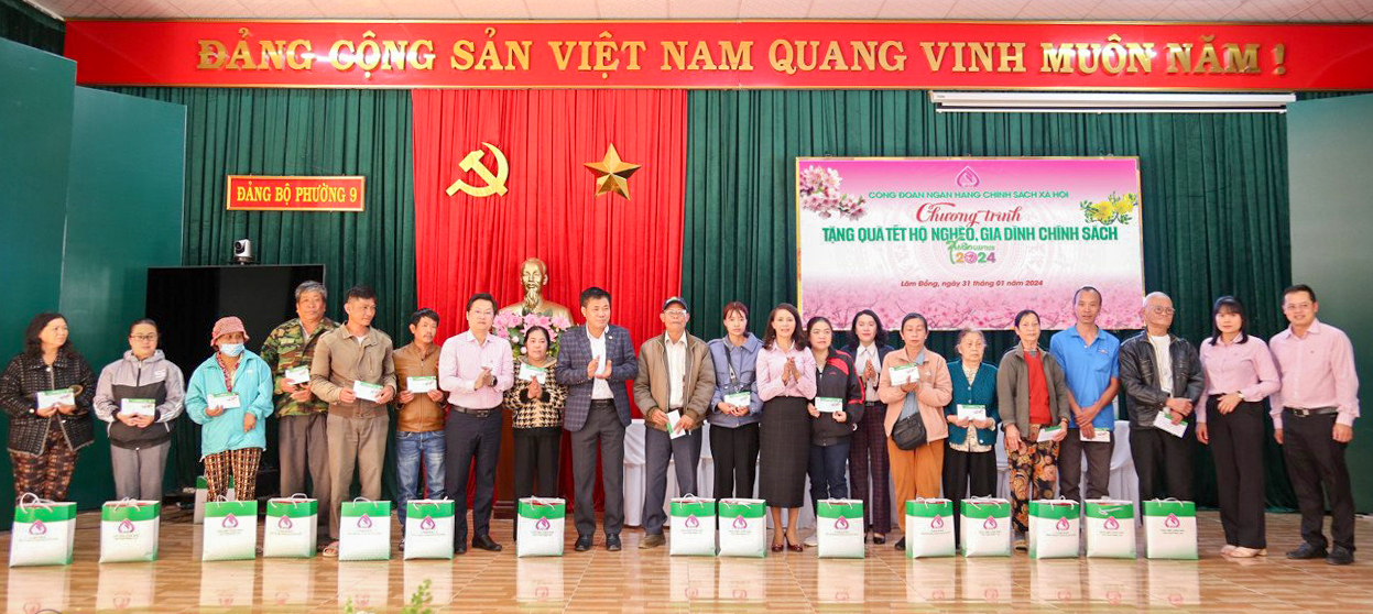 Bà Nguyễn Thị Ngọc Thu (áo hồng - giữa) - Giám đốc NHCSXH, ông Nguyễn Hữu Quang (áo hồng - giữa) - Phó Giám đốc NHCSXH và ông Nguyễn Văn Sơn - Phó Chủ tịch UBND thành phố Đà Lạt trao quà Tết cho các hộ gia đình ở thành phố Đà Lạt