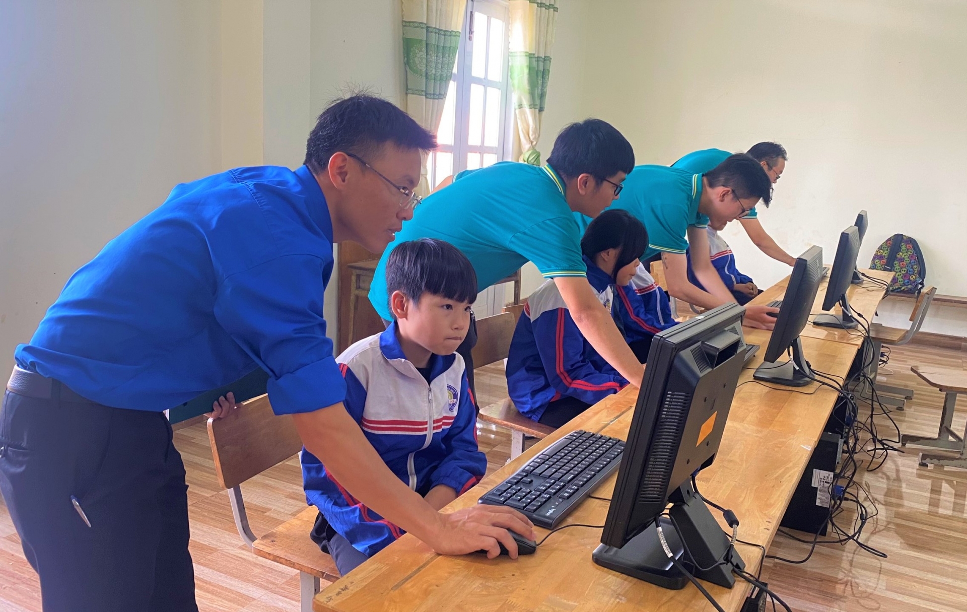 Các em học sinh trường Tiểu học Lộc Bảo (huyện Bảo Lâm) vui tươi sử dụng máy tính do Đoàn thanh niên BIDV trao tặng