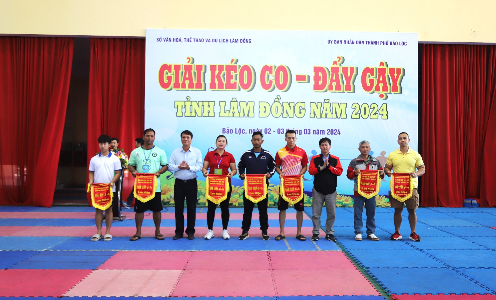 Ban tổ chức trao cờ lưu niệm cho các đội tham gia tranh tài tại giải kéo co, đẩy gậy tỉnh Lâm Đồng