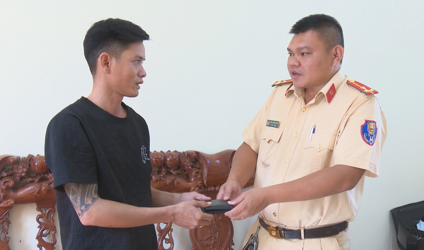 Thượng úy Đinh Quang Dũng trao trả lại chiếc ví nhặt được cho anh Mai Vũ An