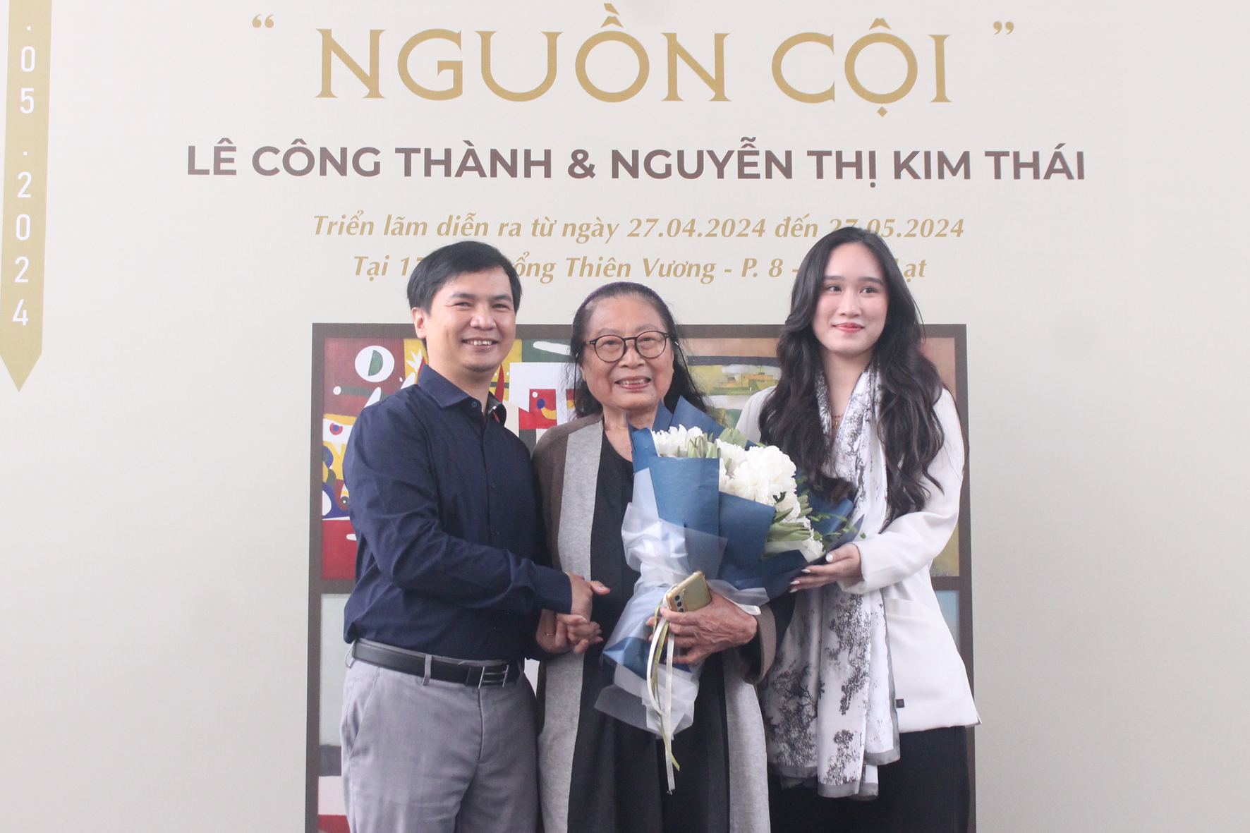 Đại diện Mimosa Gallery tặng hoa chúc mừng họa sĩ Nguyễn Thị Kim Thái (giữa)