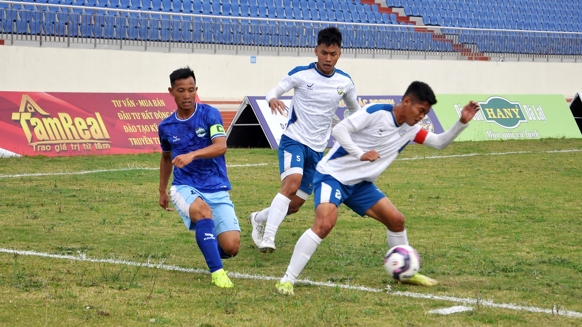 Các cầu thủ An Giang (áo trắng) chặn bóng trong một pha tấn công của Lâm Đồng (áo xanh) 