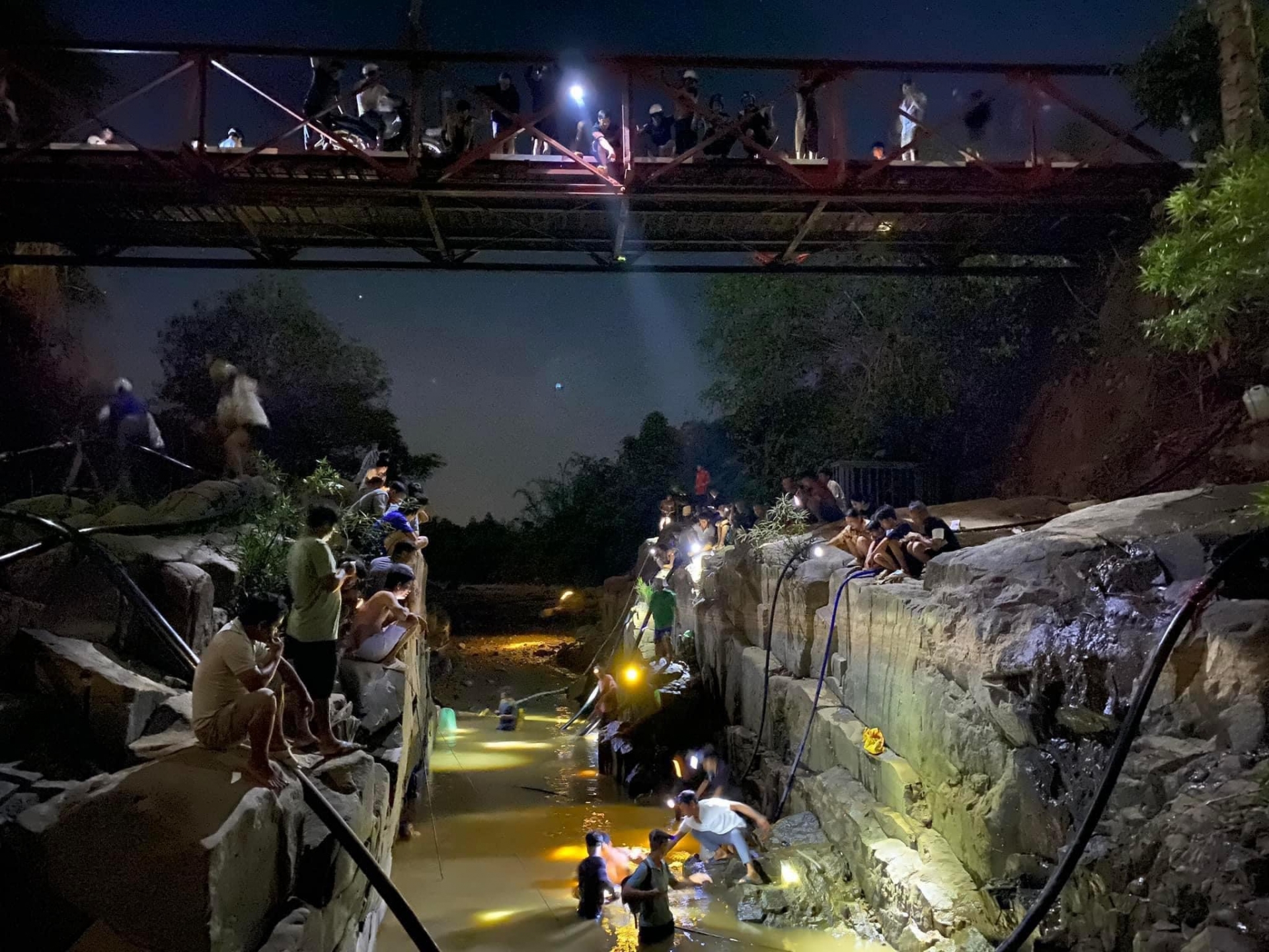 Hàng chục người dân tập trung tại cầu sắt trên sông Đạ Huoai đoạn qua Hôn 4, xã Hà Lâm bắt cá