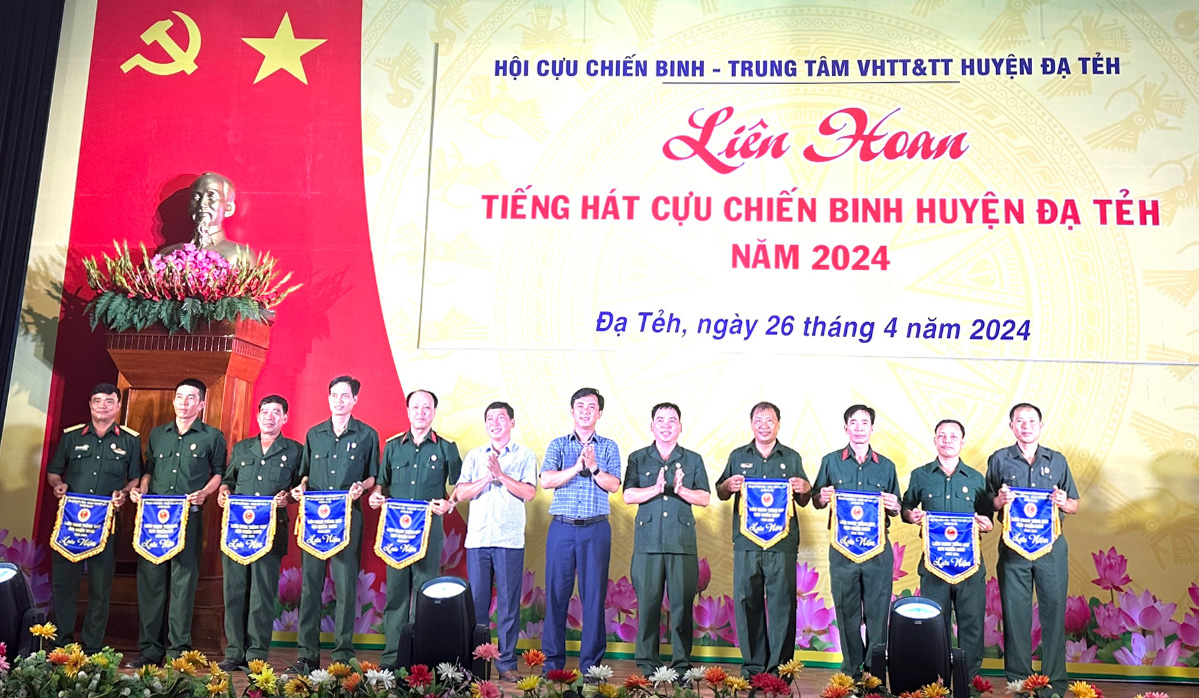Đồng chí Phan Đức Thái - Phó Bí thư Thường trực Huyện ủy Đạ Tẻh trao cờ lưu niệm cho các đơn vị tham dự hội thi