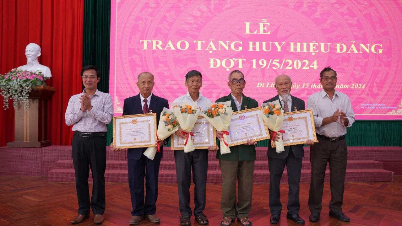 Bí thư Huyện ủy Di Linh Đinh Văn Tuấn và Phó Bí thư Thường trực Huyện ủy Di Linh K Broi trao Huy hiệu 55 năm tuổi Đảng cho các đảng viên