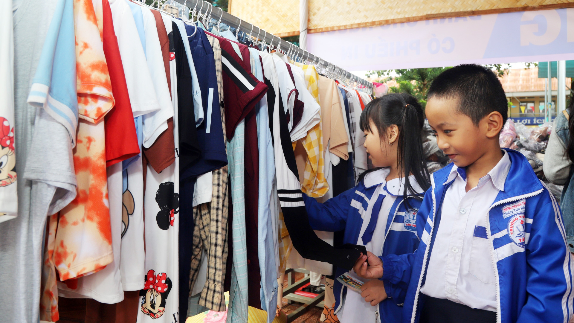 Các em học sinh lựa chọn áo quần miễn phí tại phiên chợ quê