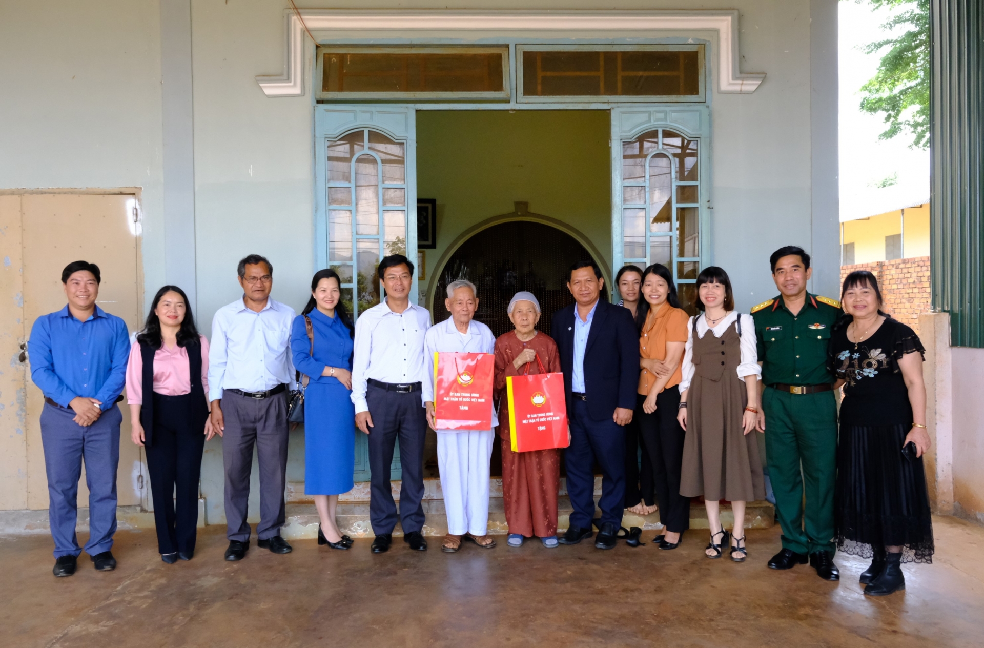 Đoàn công tác chụp ảnh lưu niệm cùng vợ chồng cựu chiến binh Lê Thị Lại và Hoàng Chí Lý