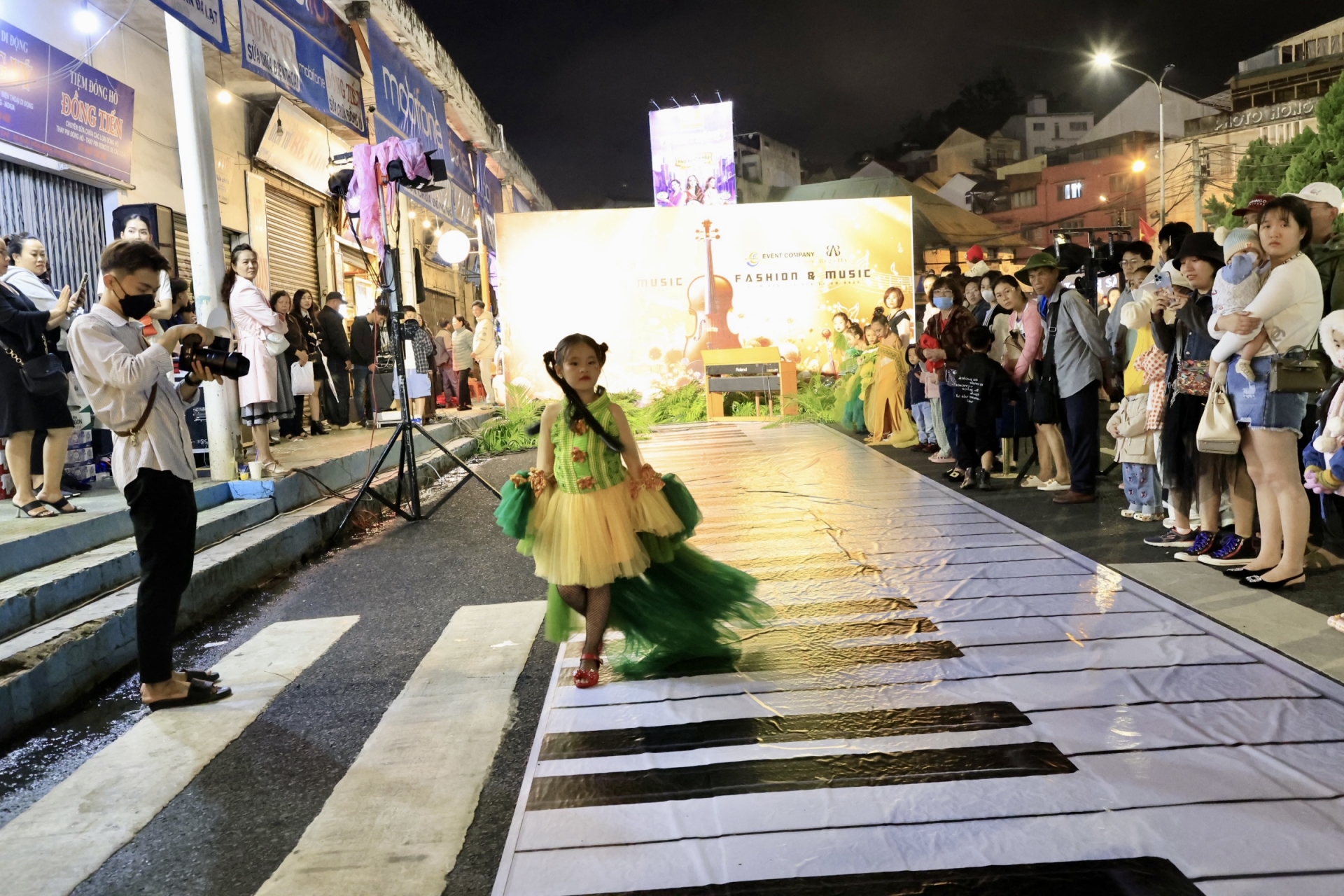 Người mẫu nhí biểu diễn thời trang trên con đường nghệ thuật bên rạp Hoà Bình, trên sân khấu mô phỏng những phím đàn Piano