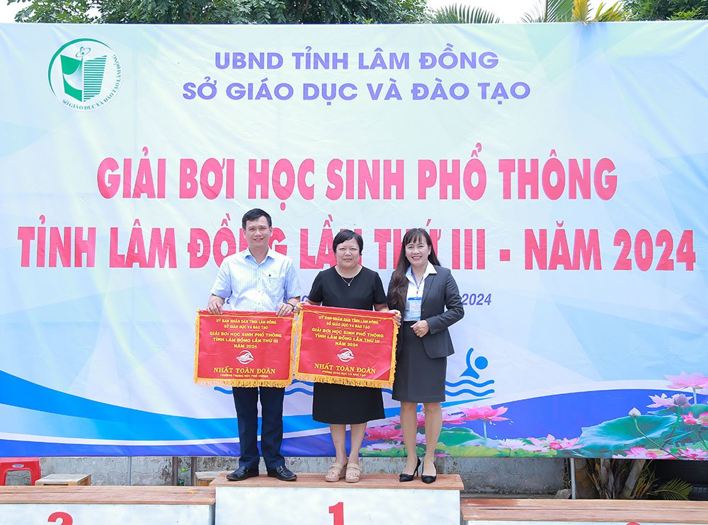 Bà Phạm Thị Hồng Hải - GĐ Sở GD&ĐT trao cờ cho hai đơn vị đạt giải Nhất toàn đoàn.