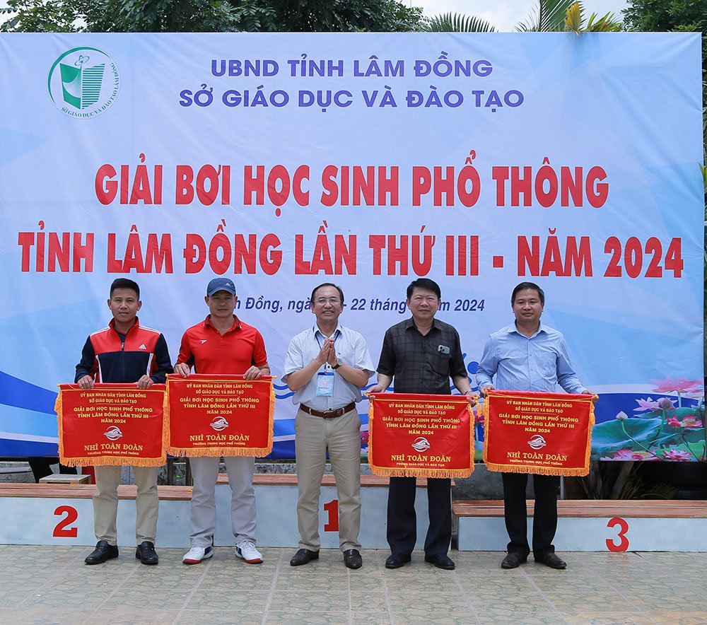 Ông Trần Đức Lợi - Phó GĐ Sở GD&ĐT, Phó Trưởng Ban tổ chức giải Bơi trao cờ cho các đội đạt giải Nhì toàn đoàn.
