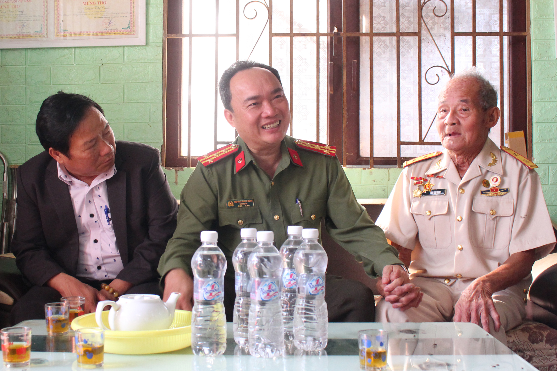 Ủy viên Ban Thường vụ Tỉnh ủy, Giám đốc Công an tỉnh Lâm Đồng Trương Minh Đương (giữa) ân cần thăm hỏi sức khỏe ông Tống Văn Đang (phải)