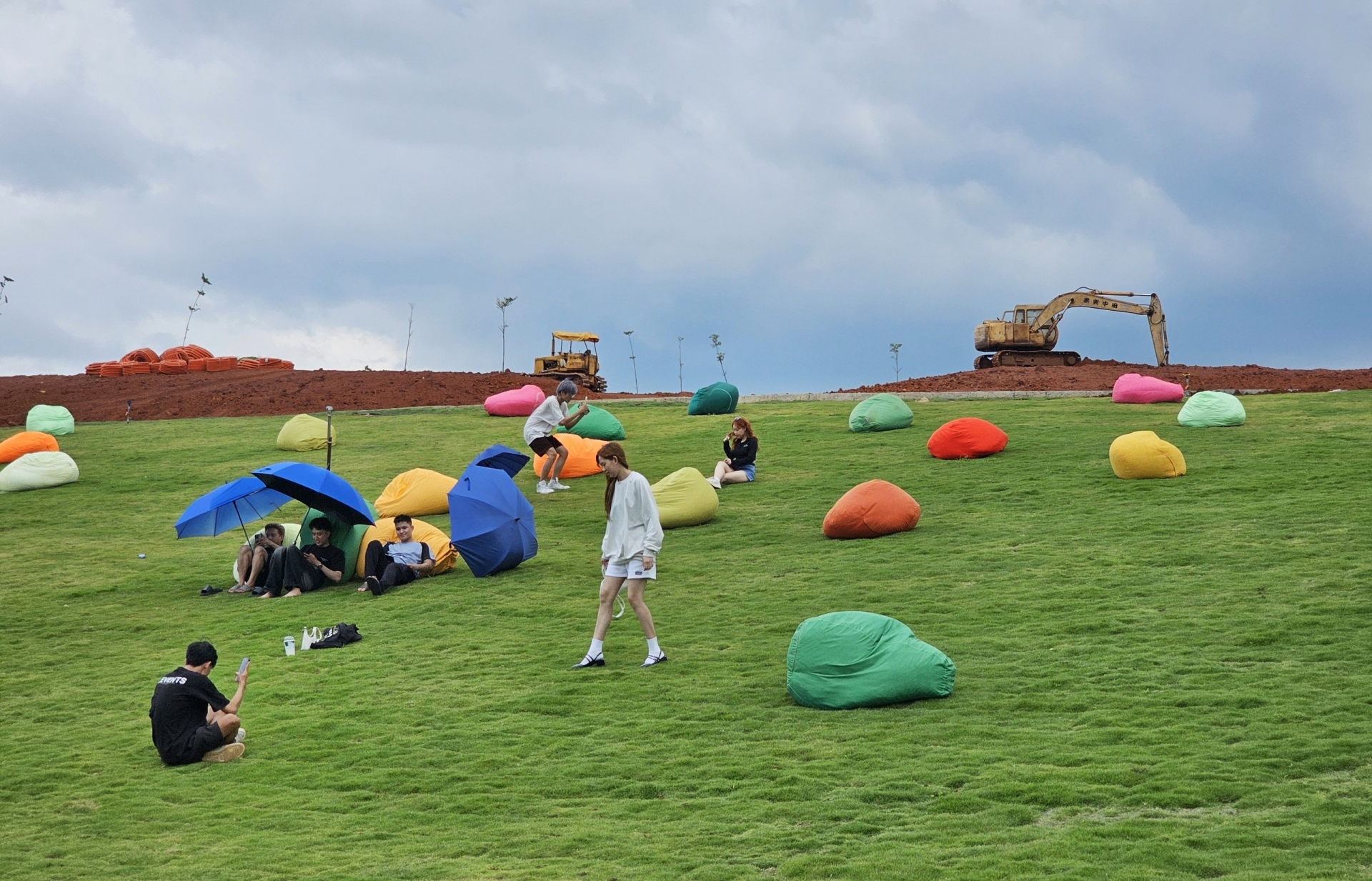 Mặc dù trên đồi cao đang diễn ra các hoạt động san gạt, nhưng du khách vẫn vô tư vui chơi ở bãi cỏ phía dưới