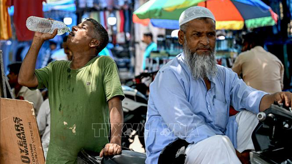 Người dân uống nước giải nhiệt trong ngày nắng nóng tại New Delhi, Ấn Độ, ngày 21/5/2024