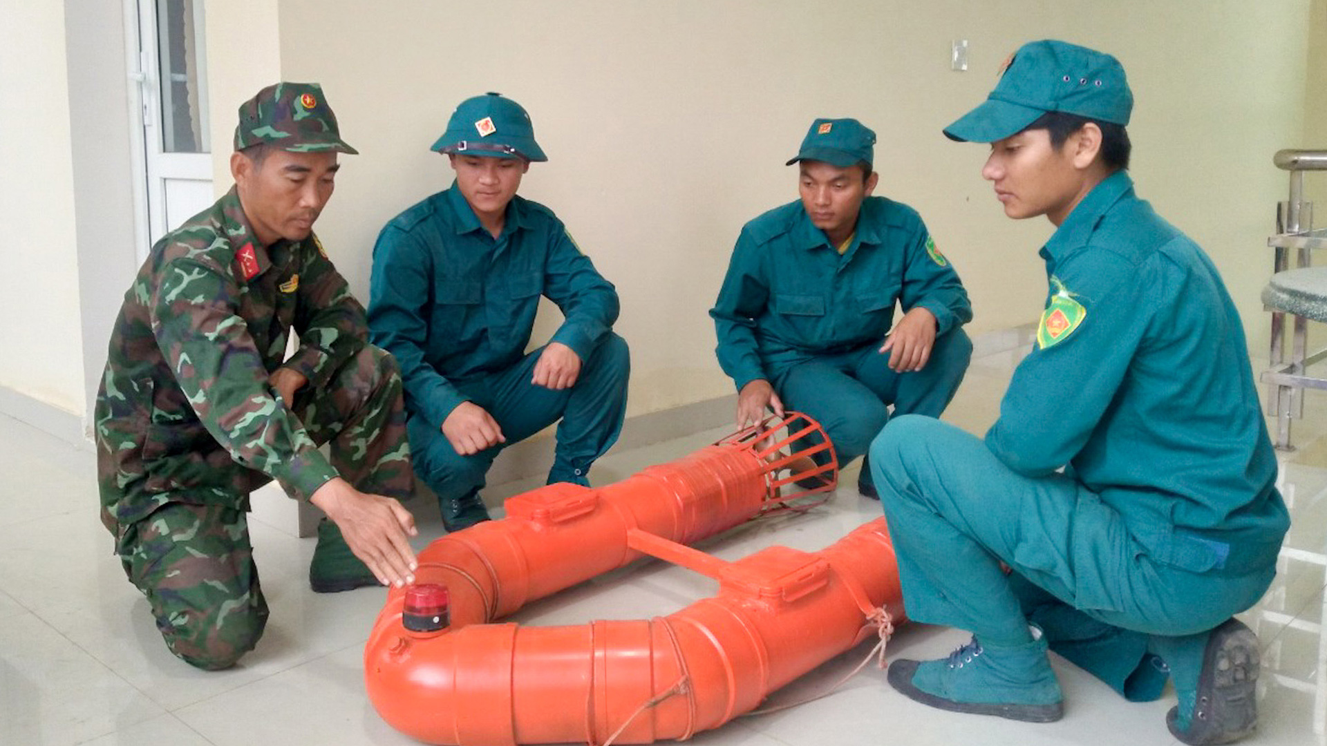 Trung tá Bùi Phạm Hoàng Anh (bên trái ngoài cùng) hướng dẫn cách sử dụng phao cứu hộ PĐK 01