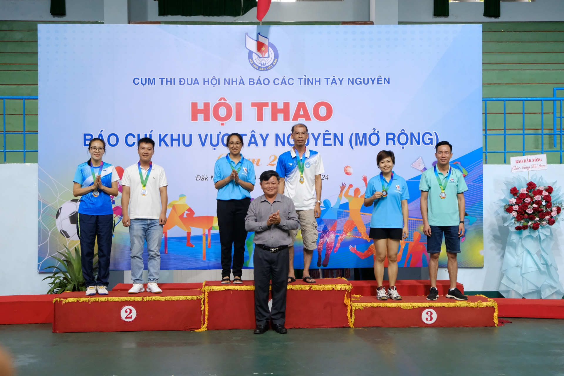 Ban tổ chức trao giải cho các vận động viên thi đấu cầu lông đơn nam, nữ