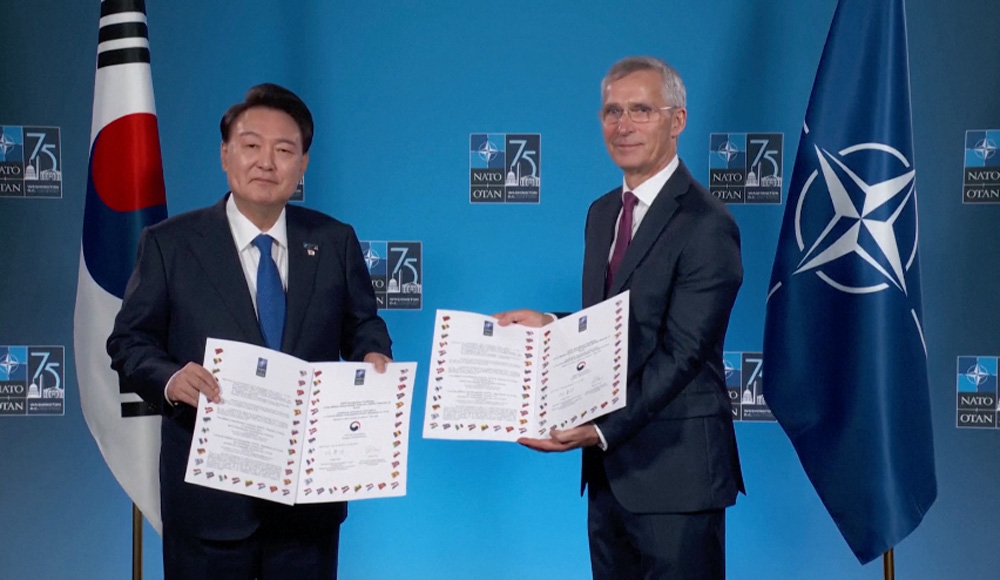 Tổng thống Hàn Quốc Yoon Suk Yeol (bên trái) và Tổng thư ký NATO Jens Stoltenberg trao đổi văn kiện ký kết ngày 11/7/2024 bên lề Hội nghị thượng đỉnh NATO ở Washington (Mỹ)