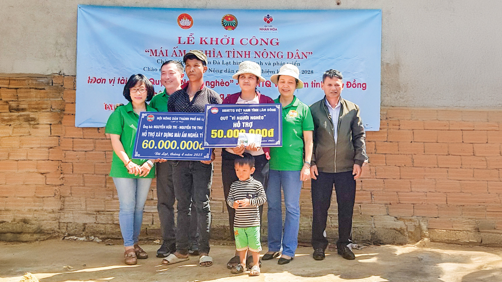 Ông Nguyễn Hữu Trí và vợ (ngoài cùng bên trái) trao tiền hỗ trợ xây nhà
cho gia đình có hoàn cảnh khó khăn