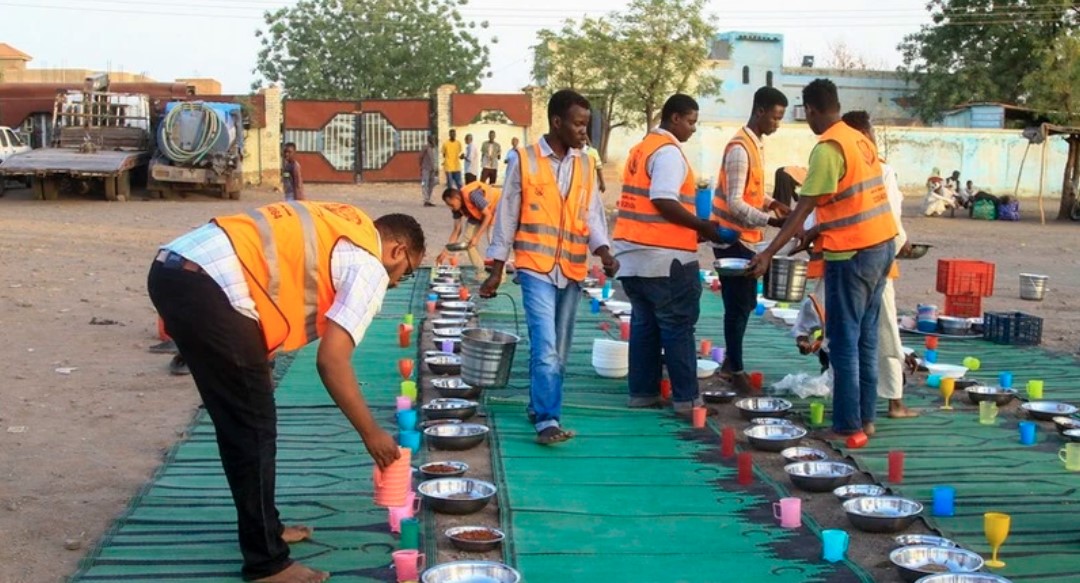 Tình nguyện viên chia suất ăn cứu trợ cho người tị nạn