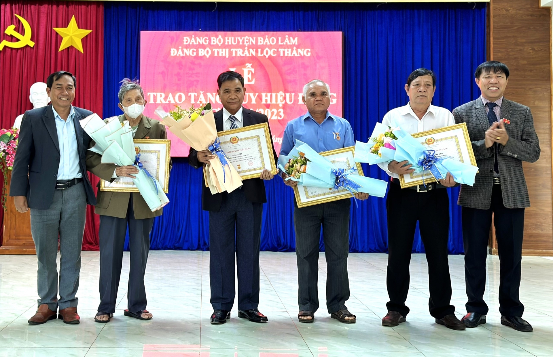 Đồng chí KLình - Phó Bí thư Huyện ủy, Chủ tịch HĐND huyện Bảo Lâm trao tặng Huy hiệu Đảng cho cấc đảng viên tại thị trấn Lộc Thắng