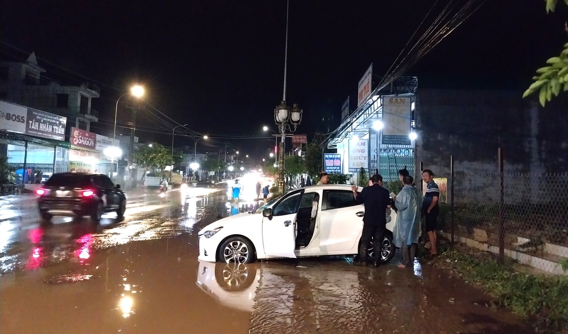 Một xe ô tô con lưu thông qua khu vực ngập sâu bị nước cuốn dạt vào lề đường hư hỏng