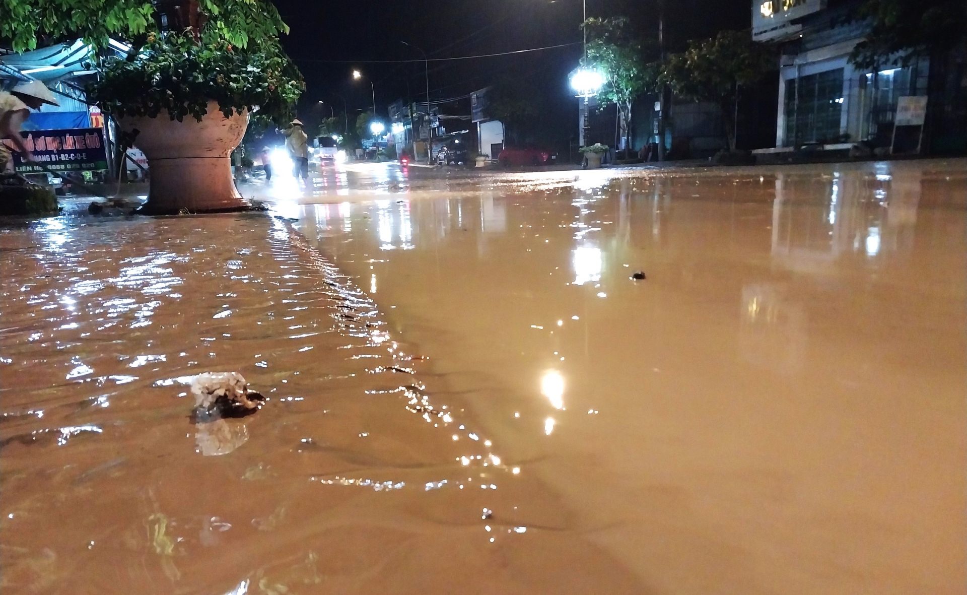 Bùn đất nhầy nhụa phủ kín mặt đường sau trận mưa lớn gây ngập khiến nhiều người lưu thông xe máy qua lại bị té ngã