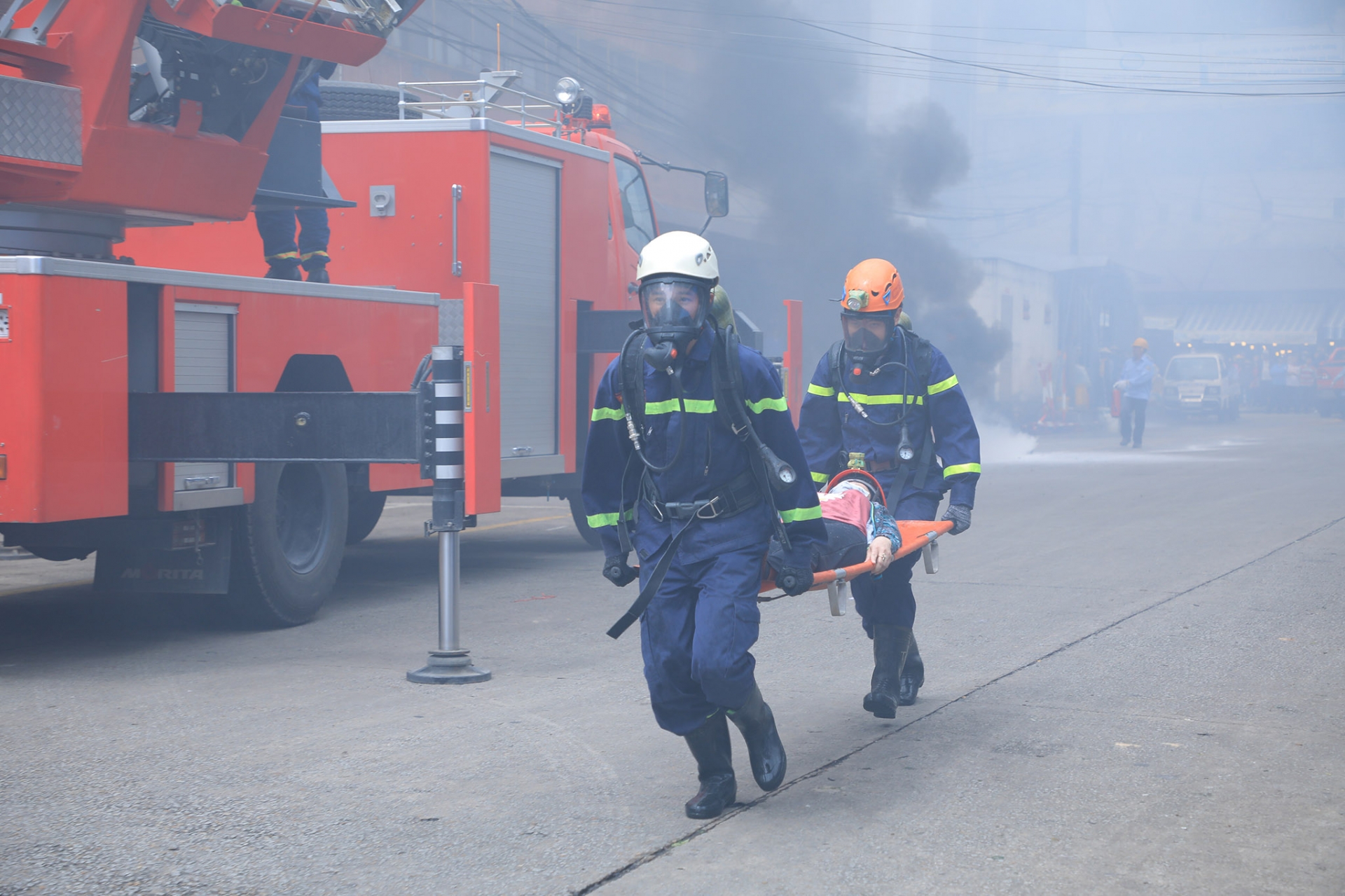 Các chiến sỹ Cảnh sát PCCC&CNCH dùng cán đưa các nạn nhân ra khỏi đám cháy