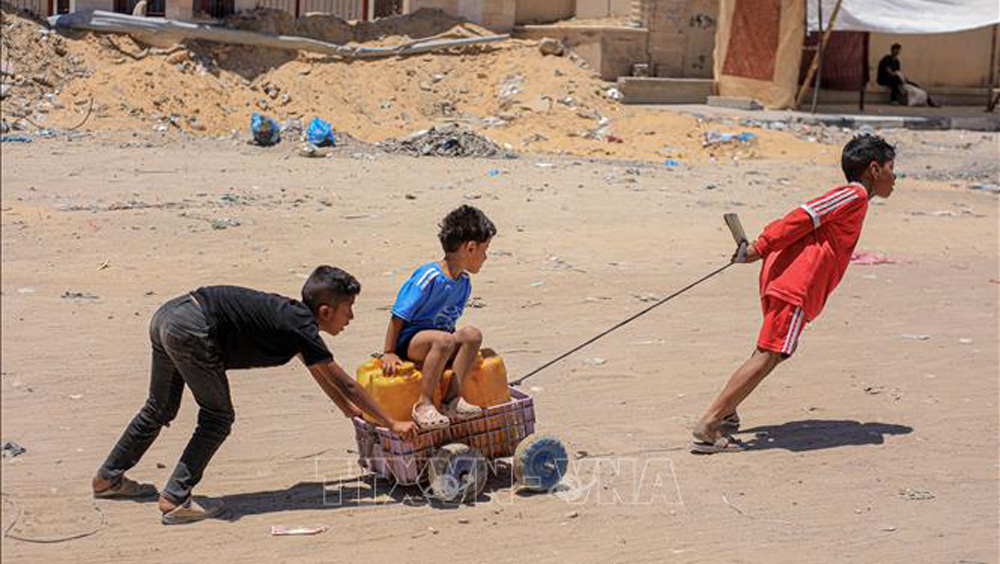 Các em nhỏ vận chuyển nước tại Khan Younis, Dải Gaza, ngày 31/5/2024