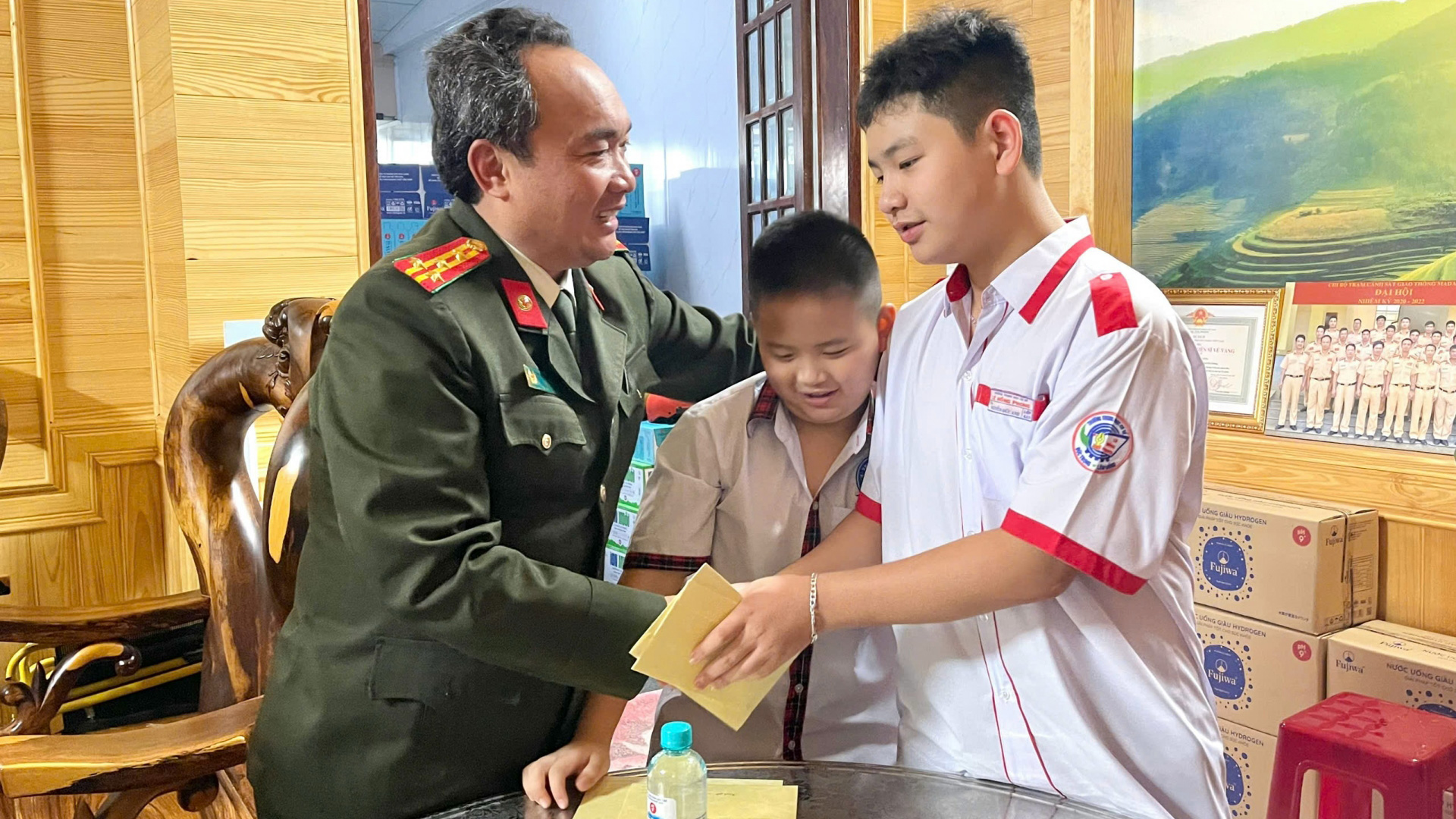 Đại tá Trương Minh Đương - Giám đốc Công an tỉnh trao quà cho các cháu là con Liệt sĩ Nguyễn Khắc Thường nhân dịp năm học mới