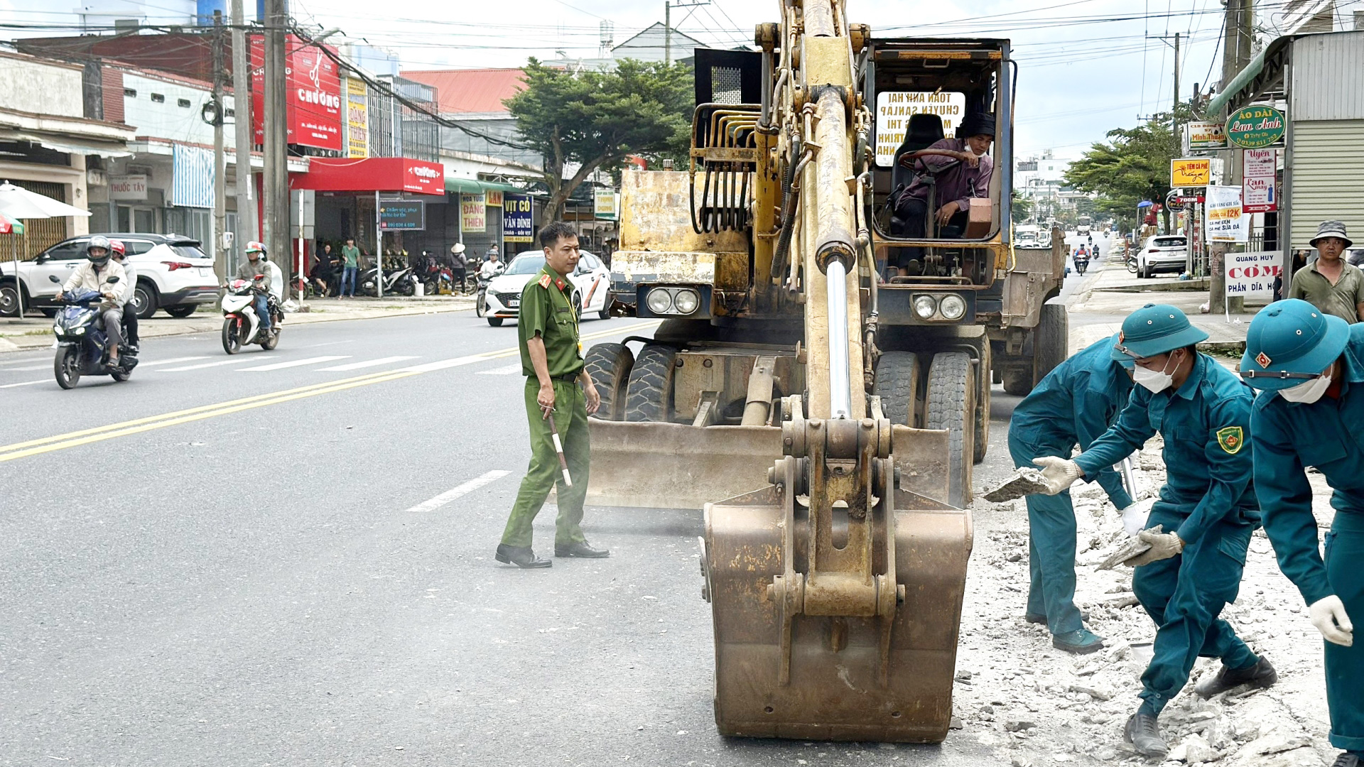 Các lực lượng tham gia tháo dỡ bó vỉa do người dân tự xây dựng lấn Quốc lộ 20