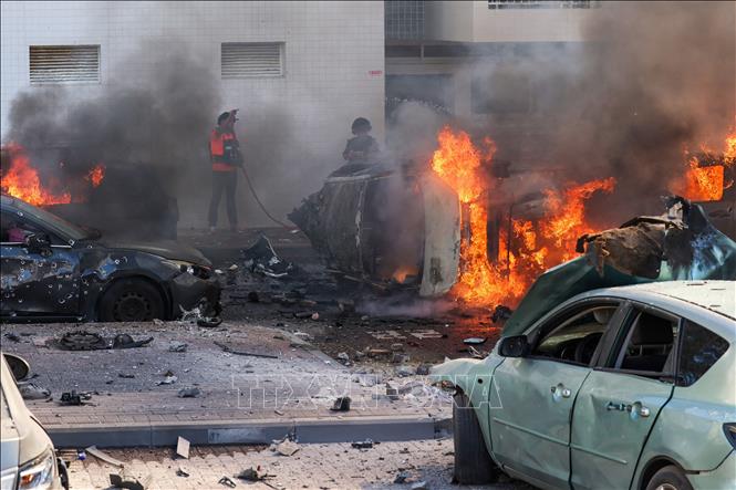 Người dân dập các đám cháy trên xe ô tô sau vụ tấn công bằng rocket từ Dải Gaza tại Ashkelon, Israel, ngày 7/10/2023