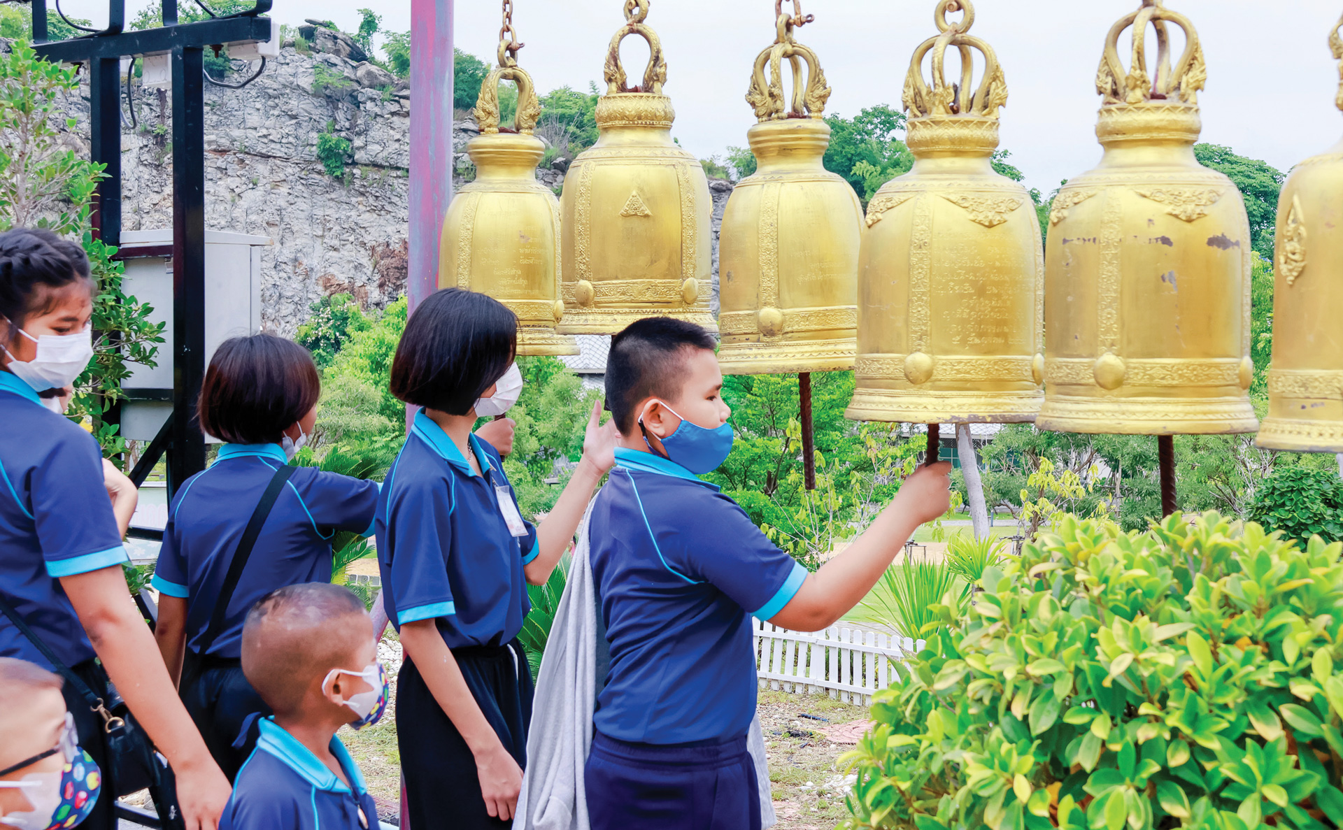 Một nhóm học sinh xếp hàng cùng rung chuông
khi đến thăm chùa