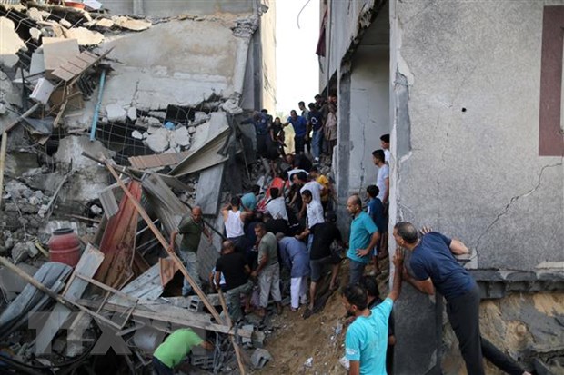 Người dân tìm kiếm người bị mắc kẹt trong những đống đổ nát sau vụ không kích của Israel tại Khan Younis, Dải Gaza, ngày 11/10/2023