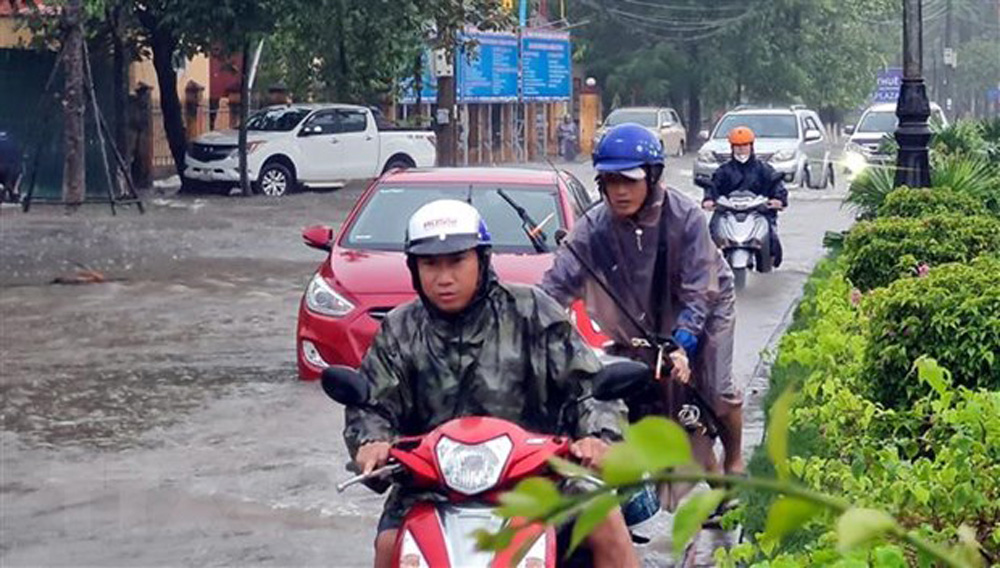 Nhiều phương tiện giao thông rất khó khăn khi lưu thông qua các tuyến đường ngập nước tại thành phố Đồng Hới