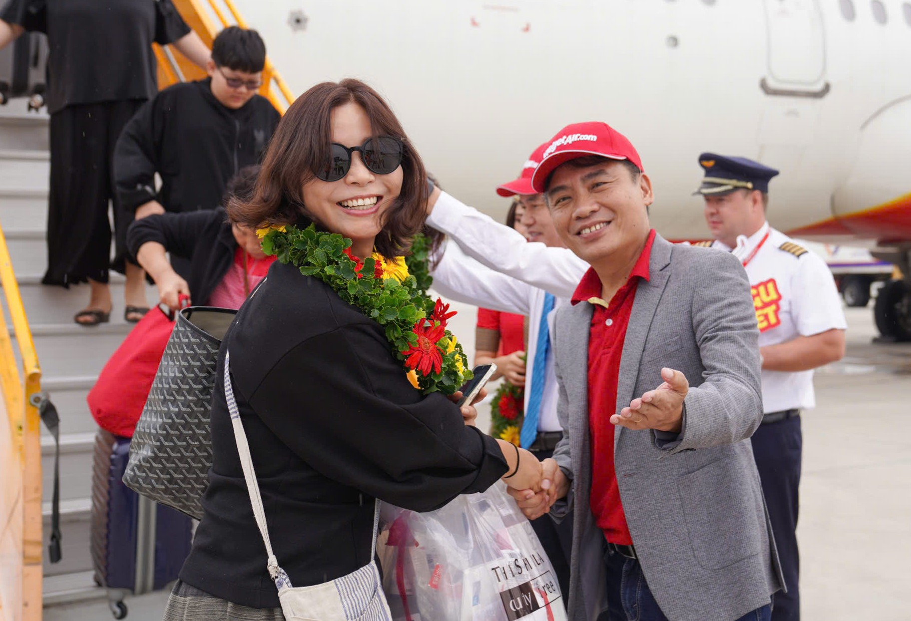 Đại diện Vietjet ông Trần Hoàng Linh giám đốc chi nhánh miền Trung tặng hoa chào mừng các hành khách trên chuyến bay khai trương Deagu - Nha Trang