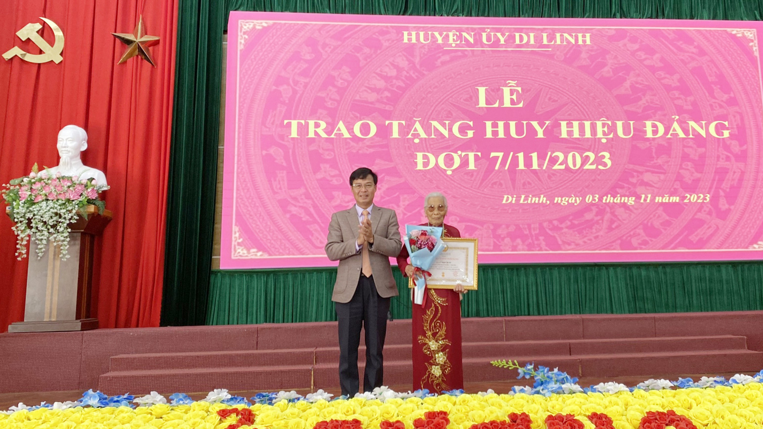 Đồng chí Đinh Văn Tuấn - Bí thư Huyện ủy Di Linh trao huy hiệu 75 năm tuổi Đảng cho đảng viên Phạm Thị Dư