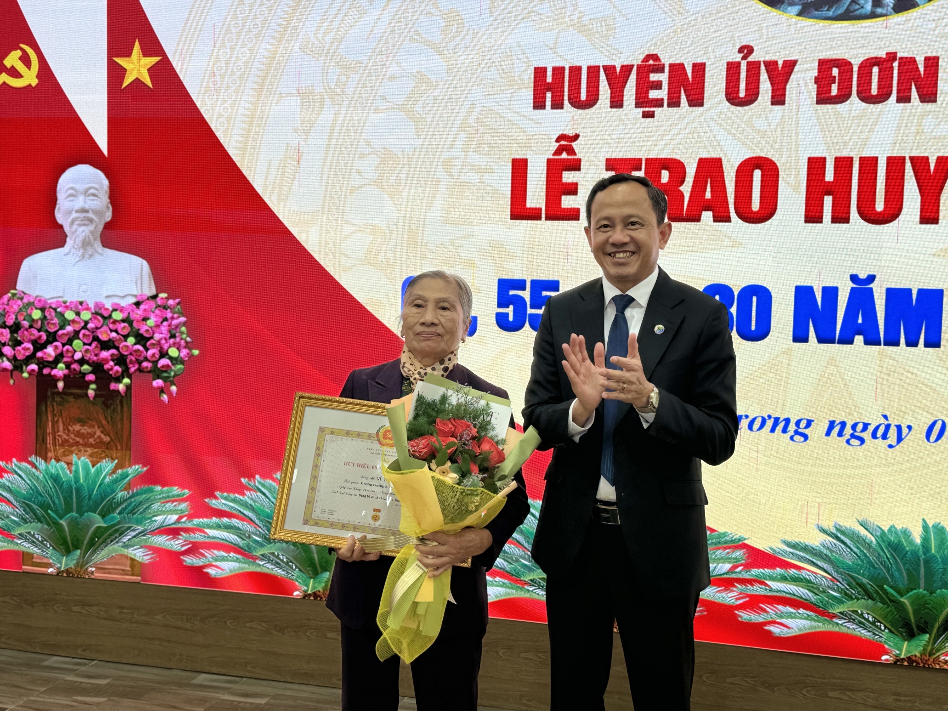Bí thư Huyện ủy Trương Văn Tùng trao tặng Huy hiệu 60 năm tuổi Đảng cho Đảng viên Vũ Thị Giáp