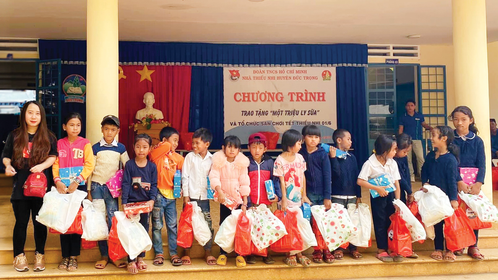 Chị Nguyễn Huỳnh Nhật Hà (ngoài cùng bên trái) trao quà cho các em thiếu nhi