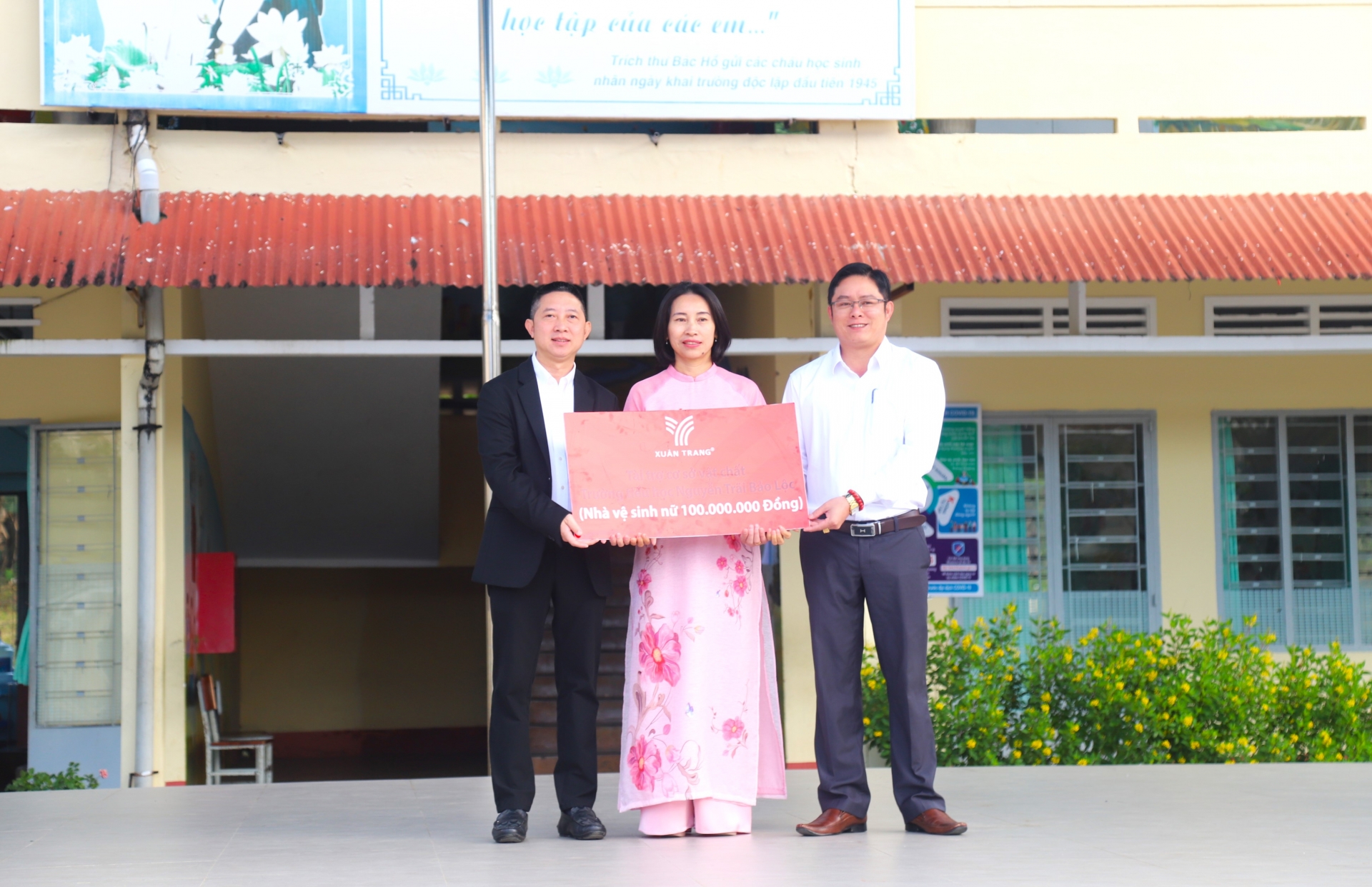 Ông Phạm Minh Đăng - Giám đốc Mỹ phẩm Xuân Trang trao tặng bảng biểu trưng xây dựng công trình nhà vệ sinh trị giá 100 triệu đồng cho Ban giám hiệu trường Tiểu học Nguyễn Trãi