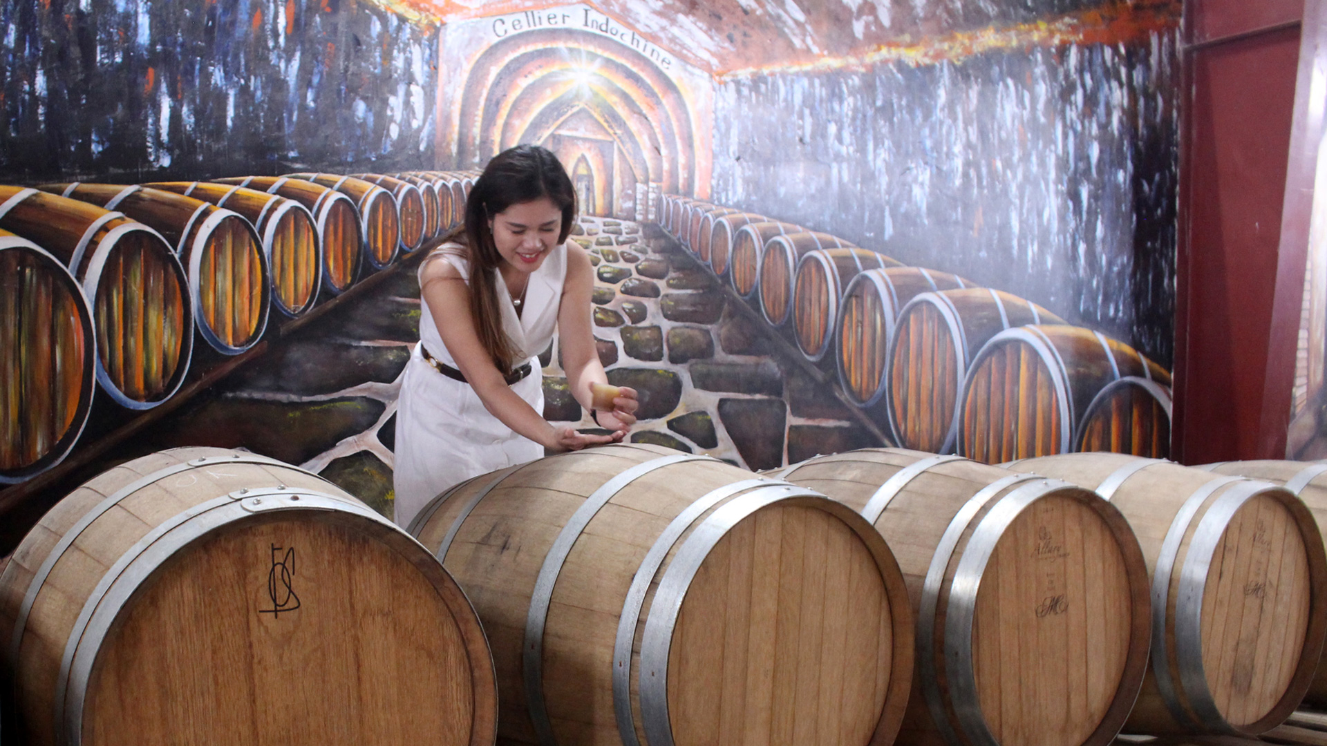 Chị Hồng Hạnh bên thùng rượu vang của nhà máy