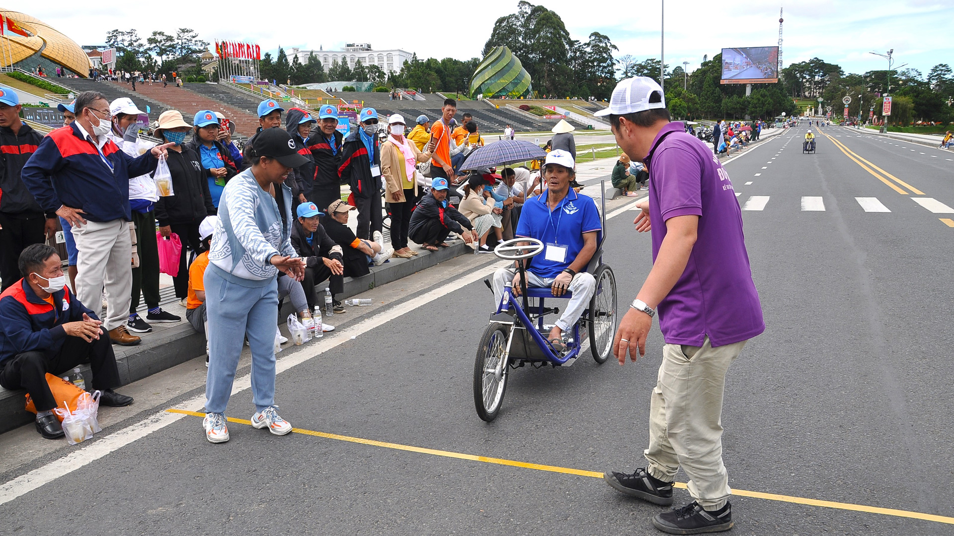 Một tình nguyện viên áo tím của Nhóm Tình nguyện Đức Trọng hỗ trợ một VĐV khuyết tật đang về đích 
tại Giải Thể thao Người khuyết tật Lâm Đồng tại Đà Lạt tháng 11/2023