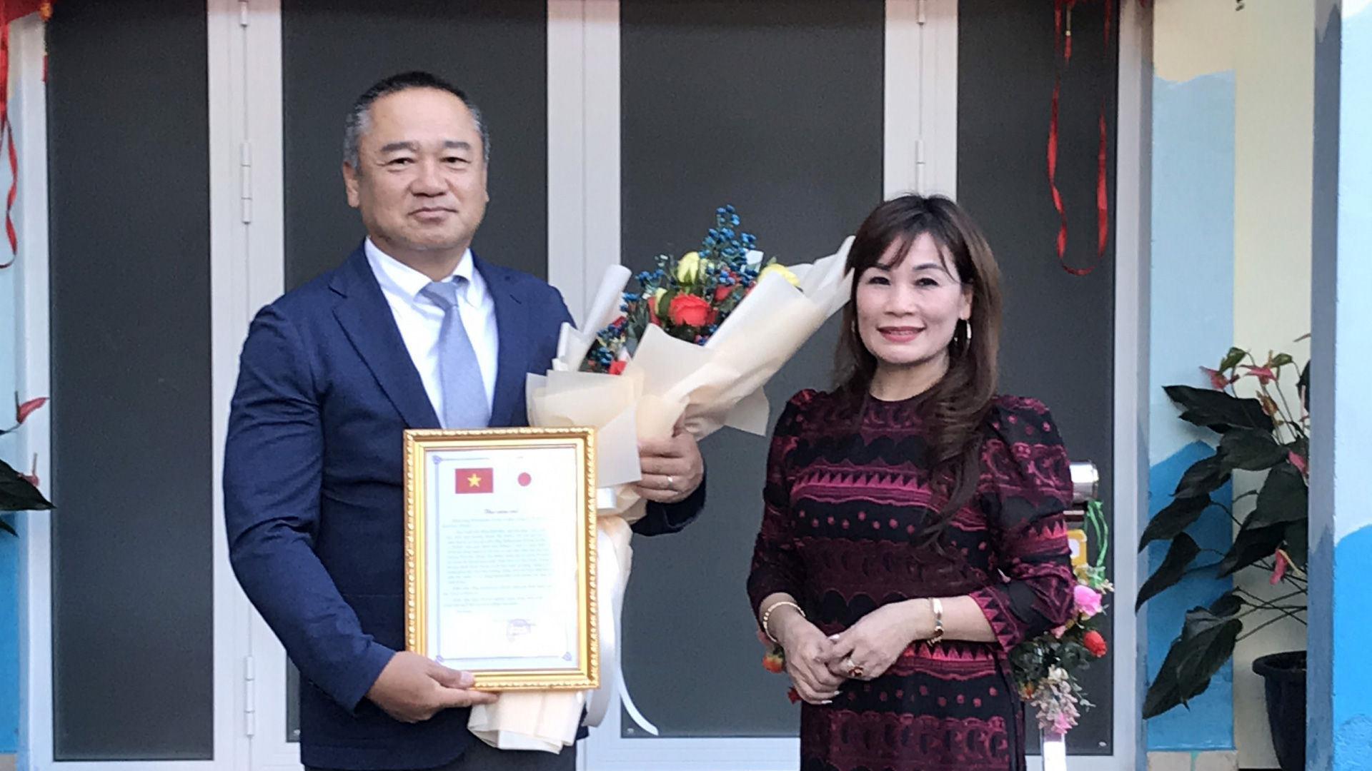 Lãnh đạo Trường Tiểu học Đoàn Thị Điểm trao thư và hoa cảm ơn ông Shibayama Eiichi - đại diện Công ty TNHH sàn giao dịch hoa Himeji, Nhật Bản