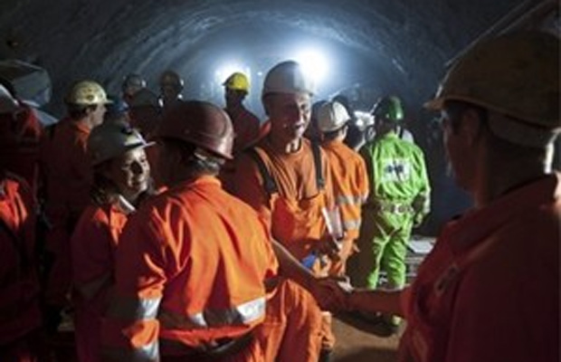 Các công nhân bắt tay chúc mừng nhau khi xuyên thủng phần đất đá cuối cùng của đường hầm ngày 15/10.