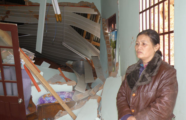 Chị Đinh Thị Lợi rầu rĩ trước nhiều tài sản và hai chiếc xe máy đang bị vùi dưới đống đổ nát của ngôi nhà. Ảnh: M. Đạo