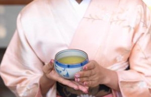 Người phụ nữ Nhật Bản bưng cốc trà xanh.