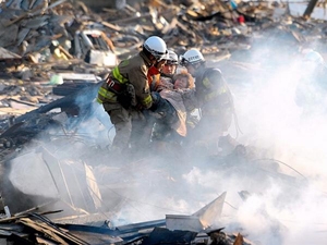 Các nhân viên cứu hộ giải cứu một phụ nữ từ đống đổ nát tại thành phố Natori-Nhật Bản, ngày 13/3. (Nguồn: EPA). 
