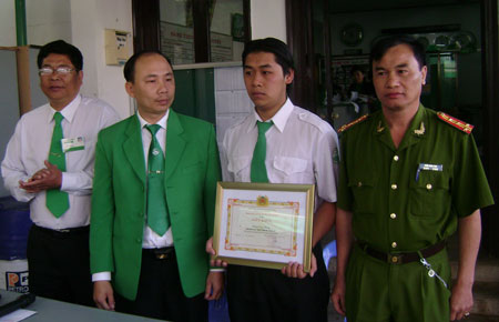 Đại tá Trần Đình Thư - Phó Giám đốc Công an tỉnh trao giấy khen cho anh Phùng Duy Phong - nhân viên lái xe công ty TNHH Mai Linh Đà Lạt.