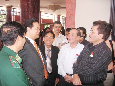 Thủ tướng Nguyễn Tấn Dũng trao đổi với ĐB bên hành lang Quốc hội khóa XII. Ảnh: Nguyễn Tuấn. 